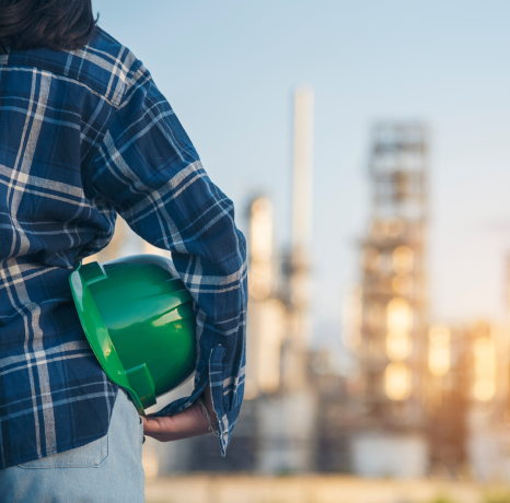 Person holding a green construction helmet in hand